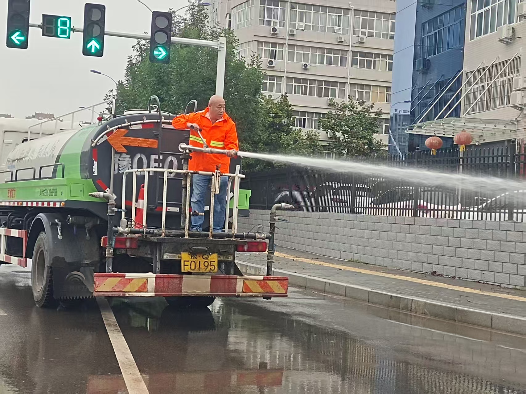 神州環(huán)境項目部主管王建設(shè)帶隊開展雨后清理、沖洗道路淤泥.jpg